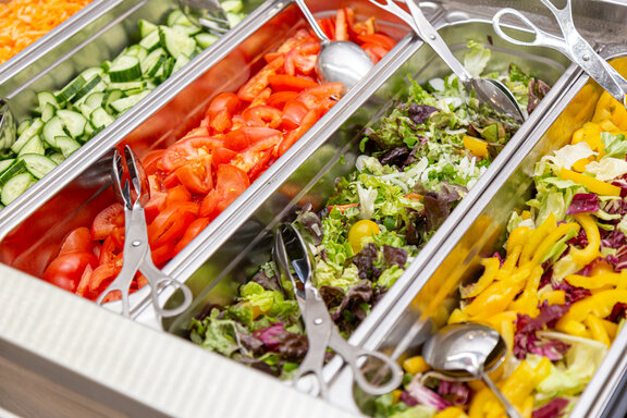 Bild einer Salatbar mit Paprika, Gurke und Salat. 