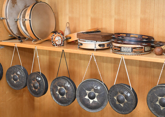 In einem Holzregal liegen verschiedene Instrumente.